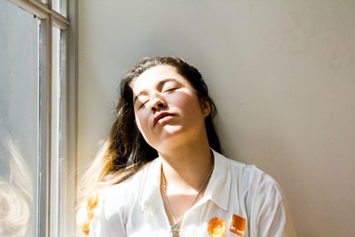 Woman standing near the window during the day
